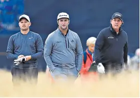  ??  ?? Elite company: Tom Lewis in practice with Jon Rahm and Phil Mickelson