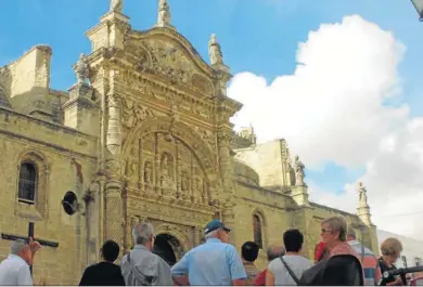  ?? D. C. ?? Un grupo de visitantes contempla la Puerta del Sol de La Prioral, situada en la fachada principal de la iglesia.