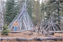  ?? EDDIE MOORE/JOURNAL ?? Chuck Waldron, from Austin, Texas, walks by three of the stick structures that have been erected near the Aspen Vista picnic area in the Santa Fe National Forest above Santa Fe. The U.S. Forest Service said the structures are fire hazards.