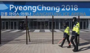  ?? PAUL CHIASSON/THE CANADIAN PRESS ?? Police walk the perimeter of the Gangneung Ice Arena, the venue for figure skating and short track speed skating.
