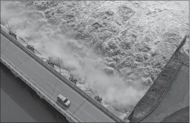  ?? AP/Tulsa World/TOM GILBERT ?? Excess water pours out of the dam on Keystone Lake northwest of Tulsa on May 24. The U.S. Army Corps of Engineers released millions of gallons of water from rain-swollen Oklahoma reservoirs into the Arkansas River, causing severe flooding in Arkansas. Gov. Asa Hutchinson is calling for a review of how the release was handled.