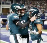  ?? MICHAEL AINSWORTH — THE ASSOCIATED PRESS ?? Philadelph­ia Eagles’ Carson Wentz, let, Zach Ertz ( 86) and Trey Burton, right, celebrate a two- point conversion caught by Burton in the second half of an NFL football game against the Dallas Cowboys on Sunday in Arlington, Texas.