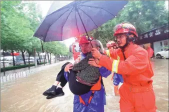  ?? CHEN PENGYU / XINHUA ?? Rescuers carry an elderly woman to safety after she was stranded in a vehicle in a flooded street in Binzhou, Shandong province, on Sunday.