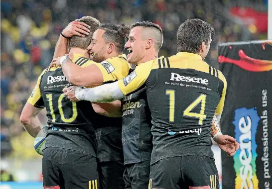  ?? PHOTOS: PHOTOSPORT, GETTY IMAGES ?? Beauden Barrett, No 10, was pretty popular with his Hurricanes team-mates after scoring this intercept try against the Chiefs.