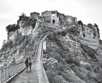  ?? DOMINIC ARIZONA BONUCCELLI/RICK STEVES’ EUROPE PHOTOS ?? A footpath is all that connects Italy’s hill town of Civita di Bagnoregio to the mainland.