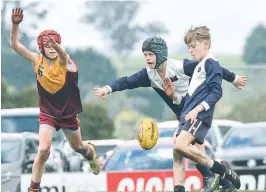  ??  ?? Left: Warragul Blues player Harry Cant beats the outstretch­ed arms of his Drouin Jets opponent during the under 12 grand final.