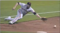  ??  ?? Giants right fielder Darin Ruf dives for a foul ball hit by the A’s Marcus Semien during the third inning on Friday in Oakland.