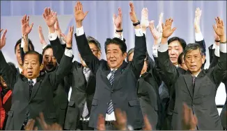  ?? SHIZUO KAMBAYASHI / ASSOCIATED PRESS 2017 ?? Japanese Prime Minister Shinzo Abe (center) and members of his ruling Liberal Democratic Party give the traditiona­l shouts of “Banzai (long life)!” during its annual convention in March 2017. Abe has pursued an economic strategy of continued stimulus...