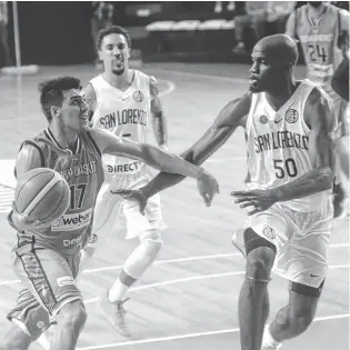  ?? FOTOS:EMMANUEL BRIANE - LA NUEVA. ?? Facundo Corvalán prepara la bandeja frente a Joel Anthony. Detrás llega Donald Sims.