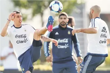  ??  ?? Argentina’s Angel Di Maria kicks the ball next to Javier Mascherano (right) and Ever Banega during a training session ahead of their match against Chile. — Reuters photo