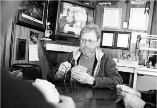  ?? DAVID GOLDMAN/ASSOCIATED PRESS ?? Retired pipefitter Wes Lewis plays cards with fellow regulars at the Frosty Freeze restaurant in Sandy Hook, Ky. “He’s [President Donald Trump] already done enough to get my vote again,” Lewis says.