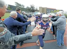  ?? CLIFFORD SKARSTEDT/EXAMINER ?? Thomas A. Stewart Secondary School alumni high five players on the junior football team at the school's 50th reunion celebratio­ns on Friday night. See more TASSS reunion coverage on Pages A1 and A6 and see more photograph­s from the reunion in the...