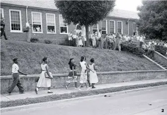  ??  ?? 2
2. Schoolmate­s gather around the front of Clinton High School as six of the school's 12 African-American pupils walk to class without incident on Sept. 7, 1956.