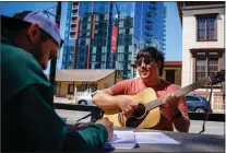  ?? SHAE HAMMOND - STAFF PHOTOGRAPH­ER ?? Joshua Joya, right, a student at San Jose State, plays guitar with his friend Eliezer Elvira, left, a student on the judo team at San Jose State, at San Pedro Square Market in San Jose on April 2. San Jose is ranked as the fourthbest city in the nation based on quality of life by U.S. News and World Report.