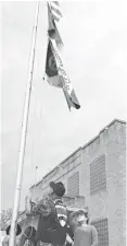  ?? The Abilene Reporter-News via AP ?? ■ LilliyAna Hernandez, 12, shades her eyes April 6 as she watches her flag being raised over Ranger City Hall in Ranger, Texas. The sixth-grader’s design was chosen from 101 entries to represent the town, which celebrated the centennial anniversar­y of its charter this month.