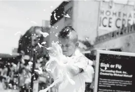  ?? CAITLIN FAW/BALTIMORE SUN ?? Patrick Brown, 7, of Pasadena claps his hands, sending “space foam” into the air at the “Sink or Fly, The Loading Dock” installati­on created by Michael Metcalf.