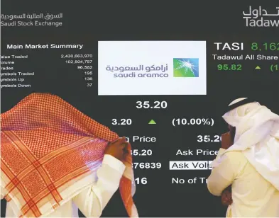  ?? AMR NABIL / THE CANADIAN PRESS / THE ASSOCIATED PRESS FILES ?? Saudi stock market officials watch the screen displaying Saudi Arabia’s state-owned oil company Aramco
after the debut of Aramco’s initial public offering on the Riyadh’s stock market in December.