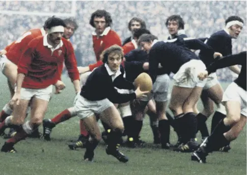  ??  ?? 0 One of his greatest performanc­es in dark blue, scrum-half Dougie Morgan looks for a pass against Wales at Murrayfiel­d in 1975.