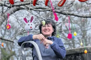  ??  ?? Easter Cathy Rowley decorating the tree in the village square