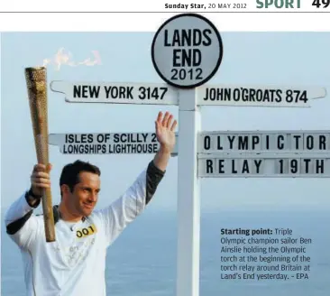  ??  ?? Starting point: Triple Olympic champion sailor Ben Ainslie holding the Olympic torch at the beginning of the torch relay around Britain at Land’s End yesterday. – EPA