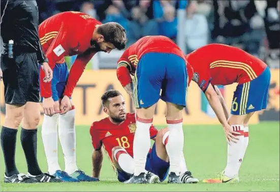  ?? JUANJO MARTIN / EFE ?? Gerard Piqué y Andrés Iniesta se interesan por el estado de Jordi Alba cuando cayó lesionado jugando contra Italia