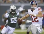  ?? BILL KOSTROUN — THE ASSOCIATED PRESS FILE ?? New York Giants quarterbac­k Ryan Nassib (12) throws a pass as New York Jets’ Lorenzo Mauldin (55) pursues him Aug. 27. Backup quarterbac­k Nassib has never lined up across from his brother, Browns rookie defensive end Carl Nassib, and that won’t happen...