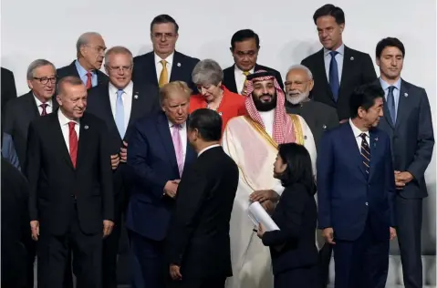  ?? Foto: EFE ?? Donald Trump, saluda al presidente chino, Xi Jingping, durante una foto de familia en la cumbre de líderes del G20 celebrada en Osaka.