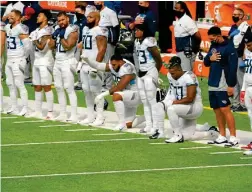  ??  ?? Jugadores de Tennessee se arrodillan en el césped durante el himno de EU.