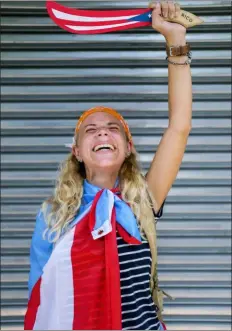  ?? DENNIS M. RIVERA PICHARDO — THE ASSOCIATED PRESS ?? Paula Martinez, 23, poses for a portrait during a march to celebrate the resignatio­n of Gov. Ricardo Rossello, in San Juan, Puerto Rico, Thursday. After weeks of flag-waving, cowbell-clanging protests in the streets, Puerto Ricans on Thursday celebrated Rossello’s resignatio­n, even as they debated where the movement should go from here and how to root out the corruption and other chronic problems that fueled the unrest.