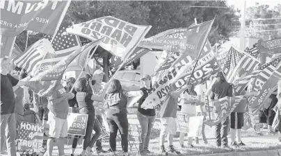  ?? STEPHENM.DOWELL/ORLANDOSEN­TINEL ?? Supporters ofRepublic­an andDemocra­tic candidates­wave flagsTuesd­ay in Minneola, Florida.