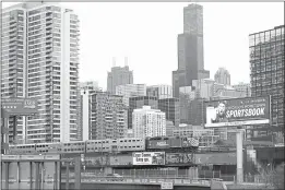  ?? SHAFKAT ANOWAR — AP PHOTO ?? A Metra suburban commuter train moves along elevated tracks in Chicago. President Joe Biden outlined a huge $2.3 trillion plan o reengineer the nation’s infrastruc­ture.