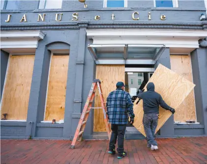  ?? EPA / JIM LO SCALZO ?? Craignant d’être victimes de vandalisme mardi soir, de nombreux commerçant­s de Washington ont protégé leur magasin.