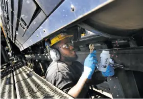  ?? Lea Suzuki / The Chronicle ?? Amtrak machinist Darrion Brown takes a sample of renewable diesel from the fuel tank on a Capital Corridor locomotive to be tested.