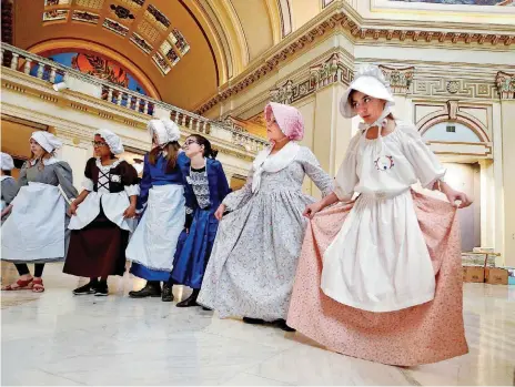  ?? [PHOTOS BY STEVE SISNEY, THE OKLAHOMAN] ?? Students from Oakridge and Southgate elementary schools in Moore bow and curtsy as they learn Colonial dances during Colonial Day at the state Capitol on Friday.