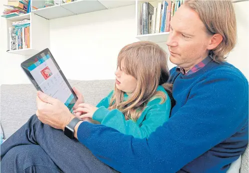  ?? PHOTOS BY AP ?? In this photo taken Oct 21, 2018, Paddy Kelly and his daughter Ailish use goHenry, one of a wave of digital banking apps for children, in London.