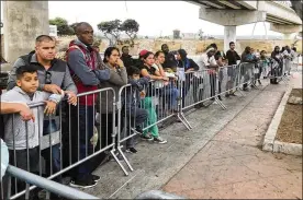  ?? ELLIOT SPAGAT / AP/ FILE ?? Asylum seekers, in Tijuana, Mexico, on Sept. 26, 2019, listen to names being called from a waiting list to claim asylum at a border crossing in San Diego. A federal appeals court has temporaril­y halted a major Trump administra­tion policy.