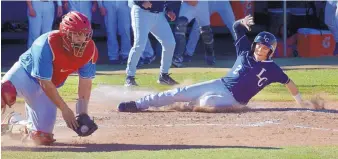  ?? GREG SORBER/JOURNAL ?? La Cueva’s Jack Pineda (2) scores as Sandia catcher Chris Hamilton surrounds a throw that was well off the plate during their game at La Cueva on Tuesday. The Bears won 12-0.