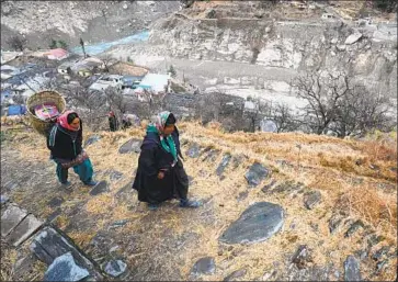  ?? Sajjad Hussain AFP/Getty Images ?? WOMEN FROM Raini Chak Lata village walk in an area in the Indian Himalayas hit by a deadly flash flood and rockslide last month. Experts say climate change and road and dam building create a dangerous brew.