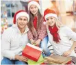  ?? FOTO: COLOURBOX.DE ?? Eine junge Familie tauscht nach den Festtagen Geschenke um, darunter auch drei „lustige“Weihnachts­mützen.