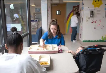  ??  ?? Inmate Doud (centre) feeds her 10-month-old daughter, Purcell, while she eats with inmate Jackson