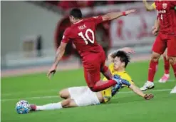  ?? — AFP ?? SHANGHAI: Brazilian forward Hulk of China’s Shanghai SIPG fights for the ball with Li Ang (bottom) of China’s Jiangsu FC during their AFC Champions League round of 16 football match in Shanghai yesterday.