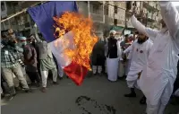  ??  ?? Burning the French flag in Karachi, Pakistan