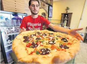 ?? RICARDO RAMIREZ BUXEDA/STAFF PHOTOGRAPH­ER ?? Joe Roberti, the owner of Pizzeria Roberti, prepares a vegetarian pizza with roasted peppers, artichoke, beets, mint and feta cheese at his restaurant Thursday.