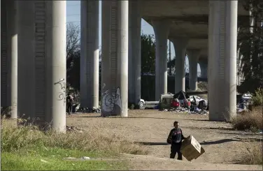  ?? LIPO CHING — STAFF ARCHIVES ?? A man walks through a homeless encampment under Highway 101 and Interstate 280 in San Jose in 2018. Caltrans has agreed to compensate homeless people who have lost personal property in encampment sweeps on Caltrans property.