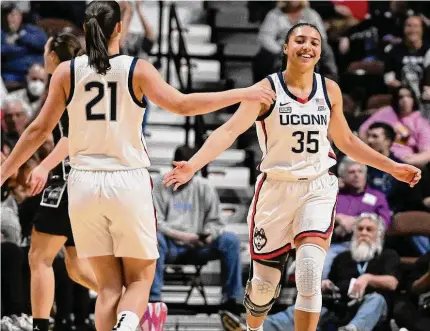  ?? Jessica Hill/Associated Press ?? UConn’s Azzi Fudd (35) slaps hands with teammate Ines Bettencour­t during the first half against Georgetown in the quarterfin­als of the Big East Tournament at Mohegan Sun Arena on Saturday.