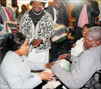  ??  ?? First Lady Auxilia Mnangagwa hands over a hamper to Mr Lovemore Matariro during her interactio­n with disabled people in Bulawayo yesterday. (Picture by John Manzongo)