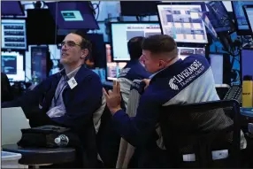  ?? (AP/Richard Drew) ?? Traders Gregory Rowe (left) and Michael Milano work Wednesday at the New York Stock Exchange.