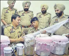  ?? SAMEER SEHGAL/HT ?? Police with ₹30.8 lakh and firearms recovered from the accused during a press conference in Amritsar on Saturday.