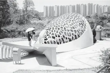  ?? WOOHAE CHO/THE NEW YORK TIMES ?? Visitors gather May 27 inside a memorial sculpture, in the shape of a yellow whale, at Danwon High School in Ansan, South Korea. The memorial honors the hundreds of students’ lives lost in the 2014 Sewol ferry disaster.