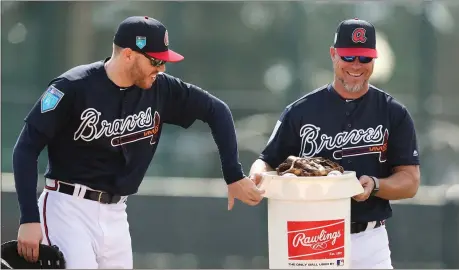  ?? Curtis Compton / Atlanta Journal-Constituti­on via AP ?? Atlanta first baseman Freddie Freeman (left) jokes with recently elected Hall of Fame third baseman Chipper Jones during spring training in Kissimmee, Fla.